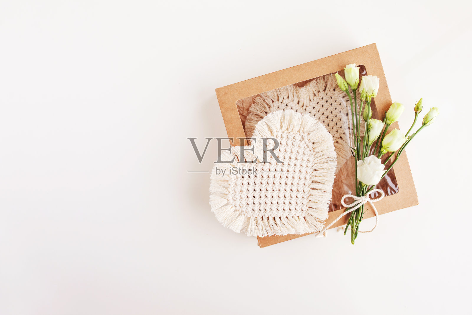 情人节礼盒与流苏装饰在白色的背景。天然材料，棉线。流苏生态装饰，饰品，手工制作的装饰。心形——节日的象征。本空间照片摄影图片