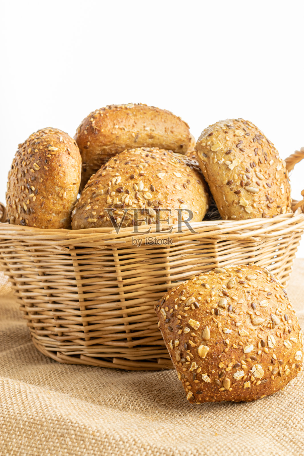 新鲜的烤面包。在亚麻质地的背景下，以小麦穗或穗状花序种植的乡村传统面包的新鲜面包。用硬面包和面包屑做的黑麦面包。健康食品的概念。照片摄影图片