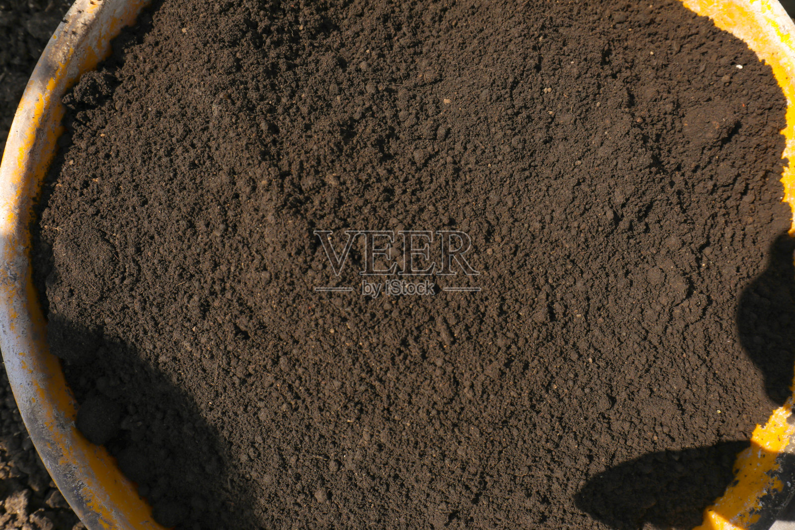 塑料罐内的黑土或堆肥照片摄影图片