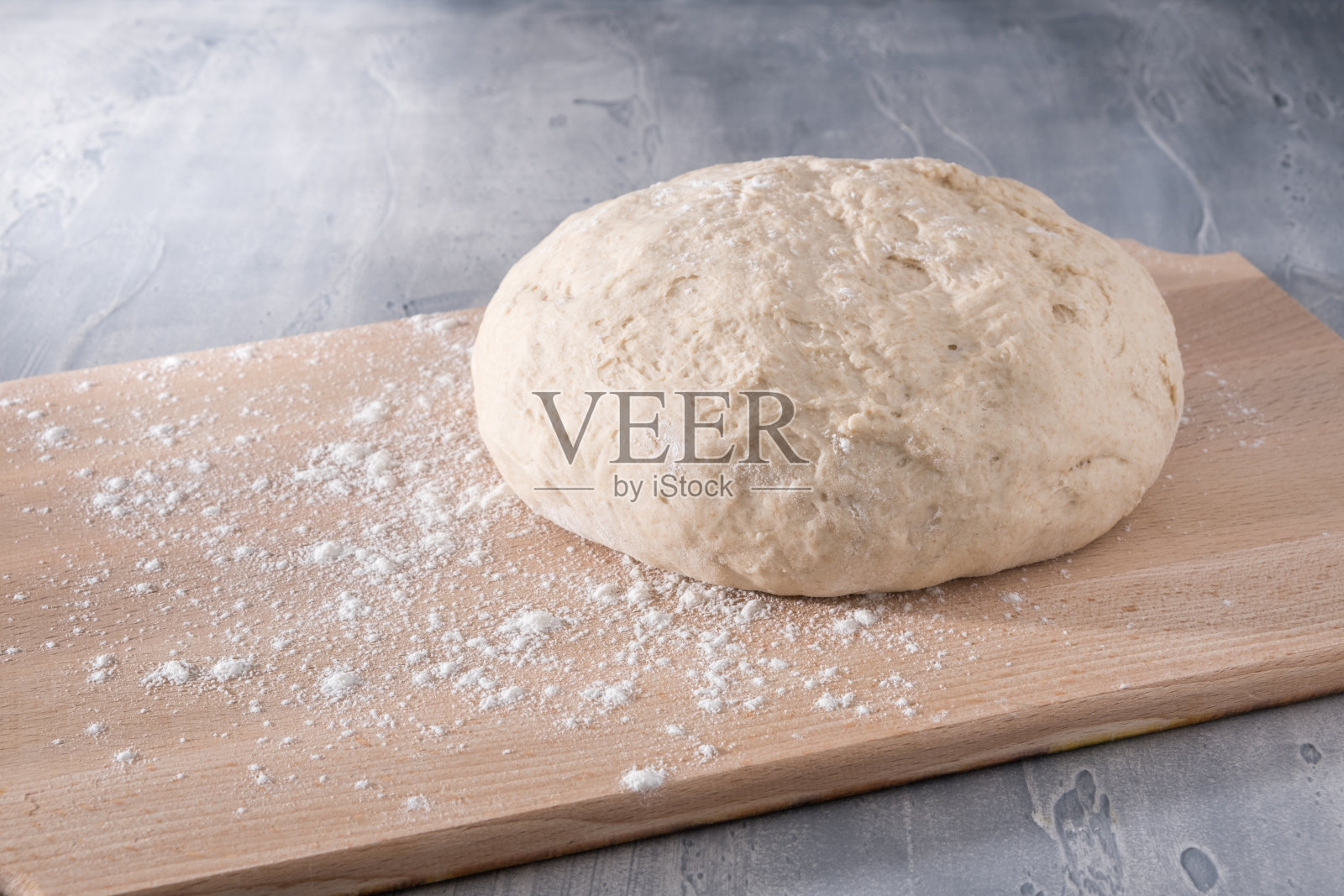 烤面包或披萨用的新鲜生面团放在木板上。照片摄影图片