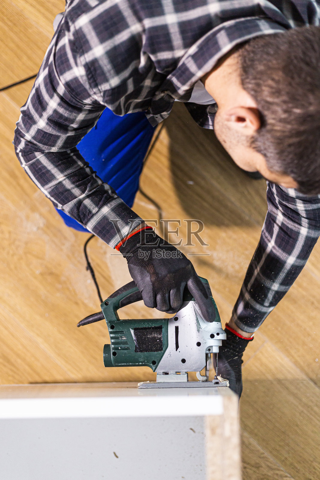 木匠用带绳的竖锯切割木头表面(木板)的一部分。照片摄影图片