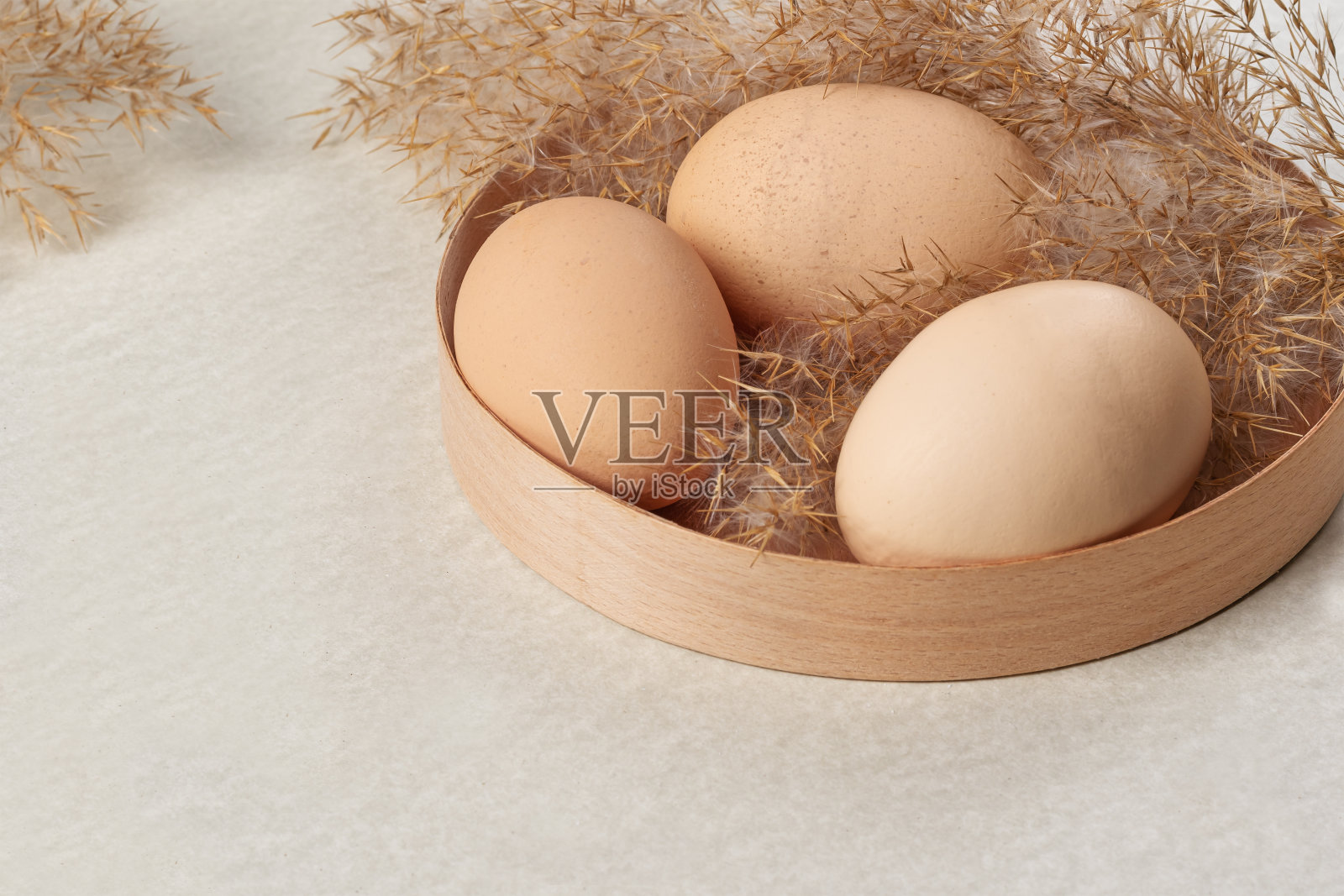 有机新鲜鸡蛋放在篮子里，背景很亮照片摄影图片