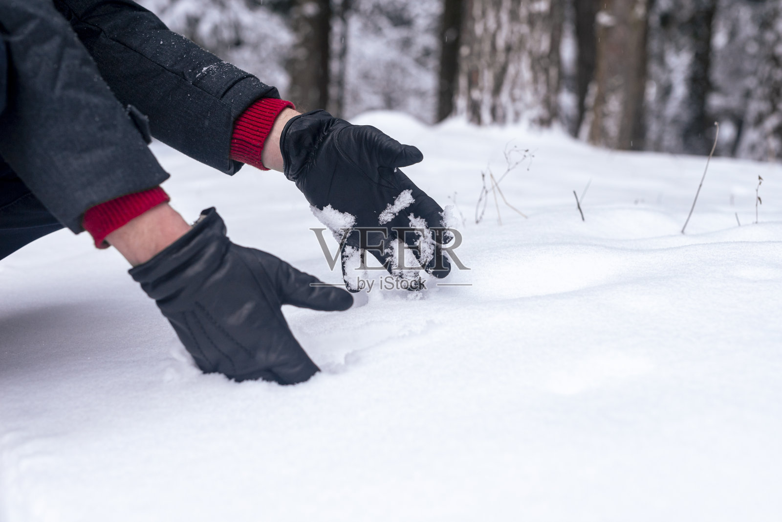 男性的手制作或塑造雪球，触摸森林里的雪，特写照片摄影图片
