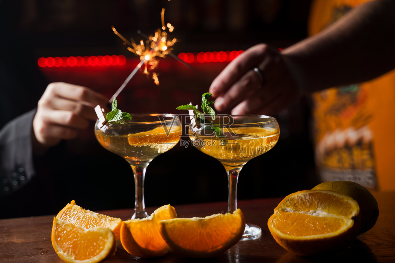 在2022年的新年前夕，人们燃放烟花，喝鸡尾酒。薄荷橙片，鸡尾酒杯装酒精鸡尾酒。照片摄影图片