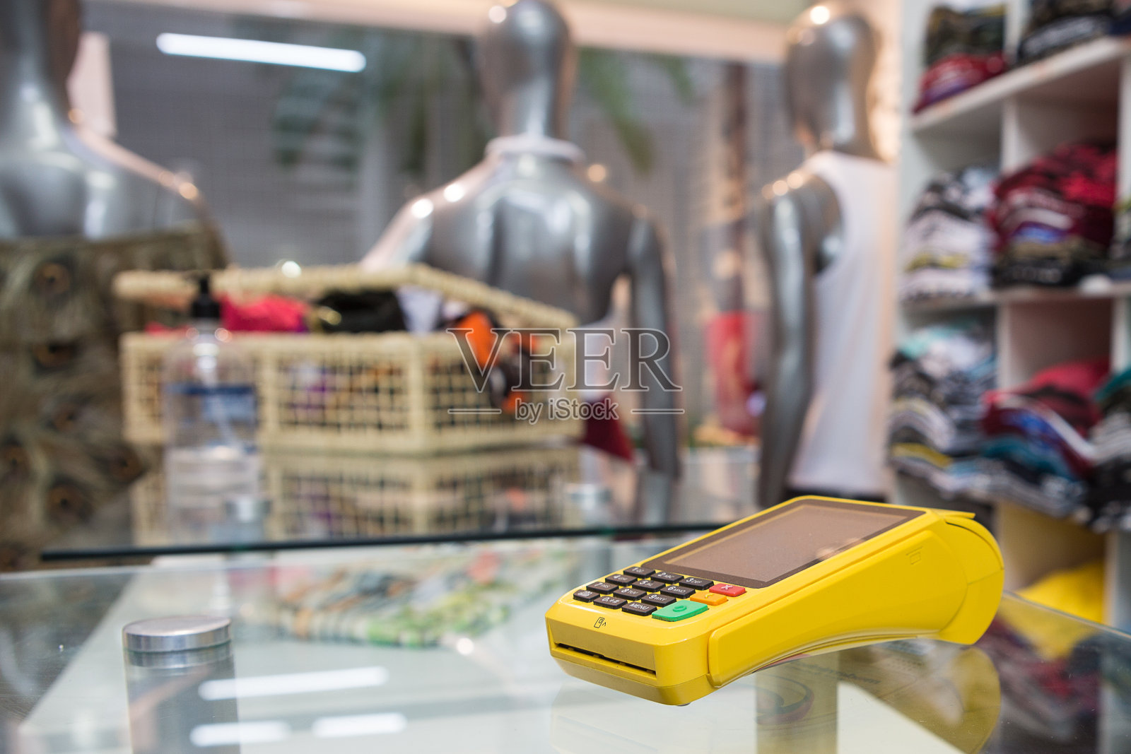 一家服装店的内部，前台有一台信用卡机照片摄影图片