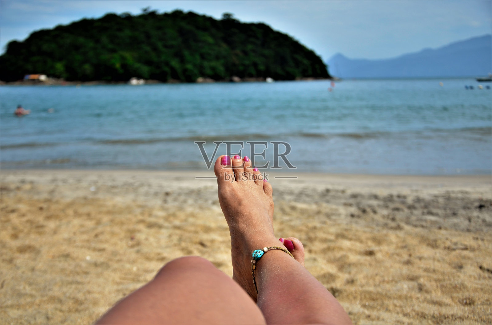 粉红色搪瓷腿放松在海滩上照片摄影图片