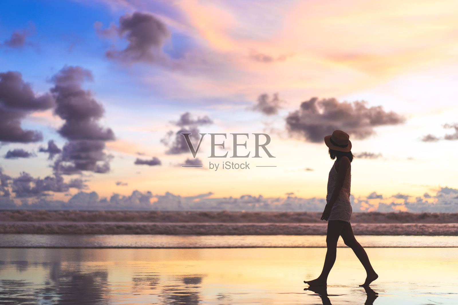 年轻的成年游客亚洲女人的后视图在美丽的日落天空的沙滩上散步放松。照片摄影图片