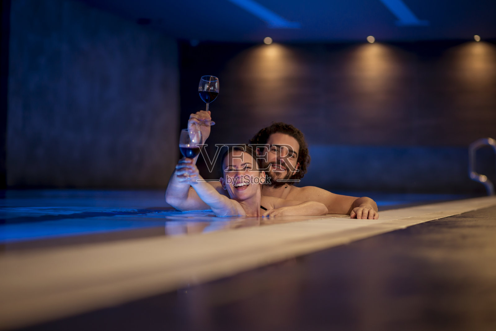 夫妇在水疗中心游泳池放松照片摄影图片