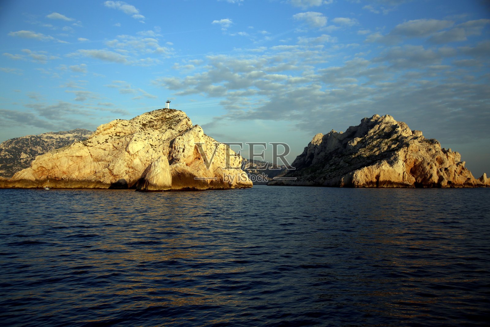 日落时蓝色海洋中的岩层，法国马赛国家卡兰克斯公园照片摄影图片