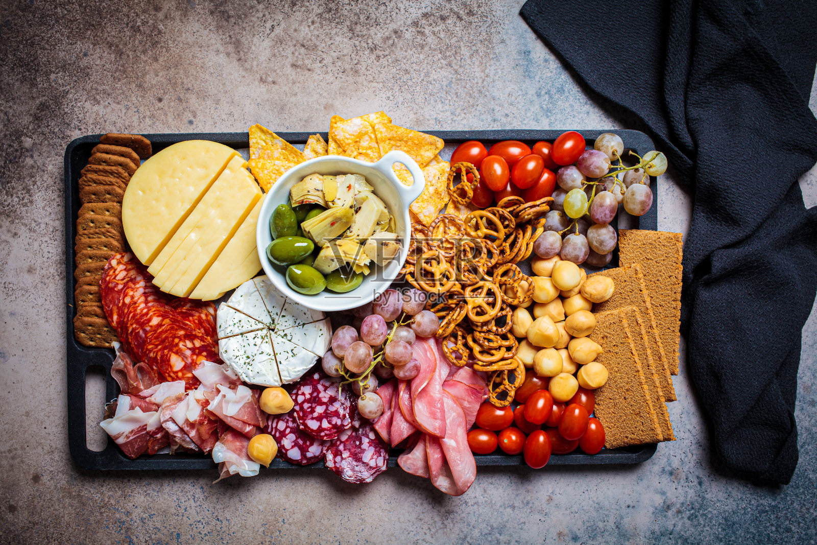 熟食和奶酪拼盘。开胃菜托盘与各种肉，奶酪，水果，橄榄和饼干。照片摄影图片