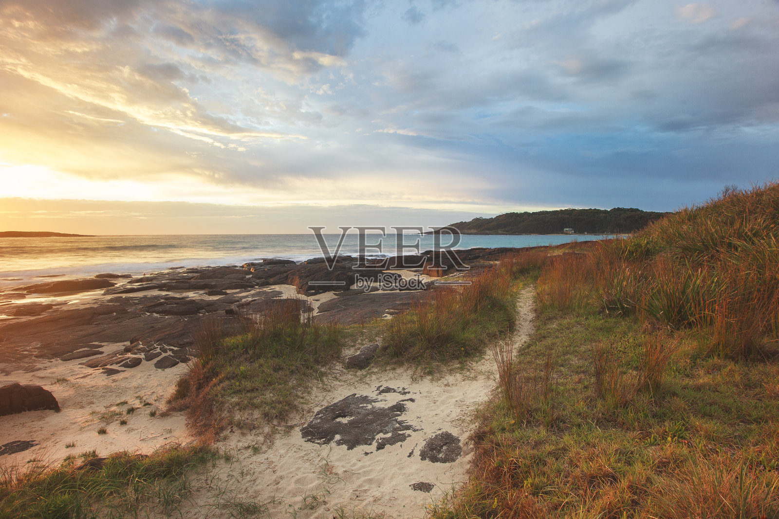 沿着海滩的海岸小径和戏剧性的早晨日出照片摄影图片