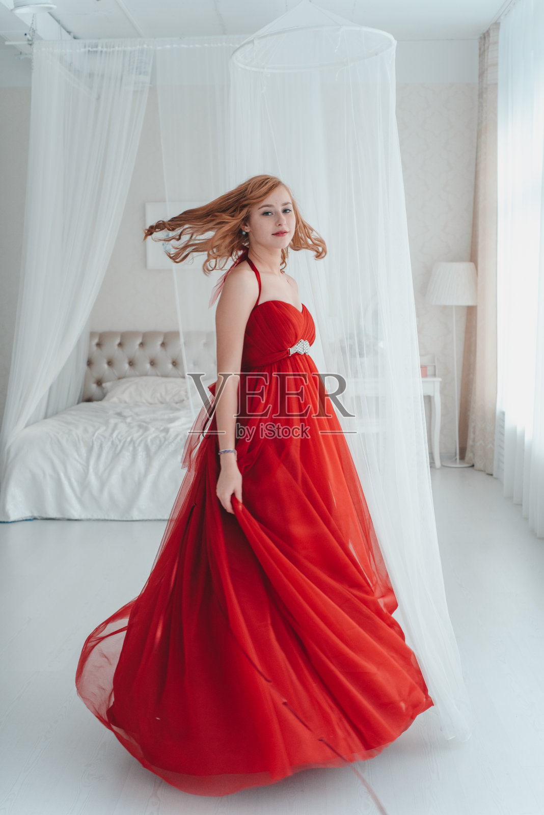 一位穿着豪华红色连衣裙的女士。照片摄影图片