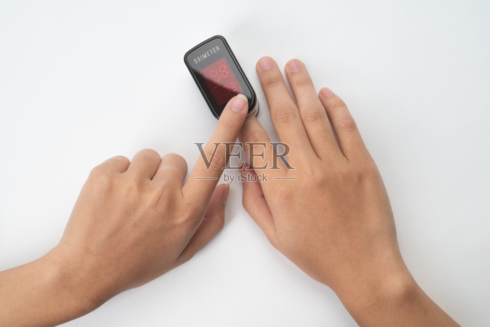 手用脉搏血氧计测量血氧饱和度照片摄影图片
