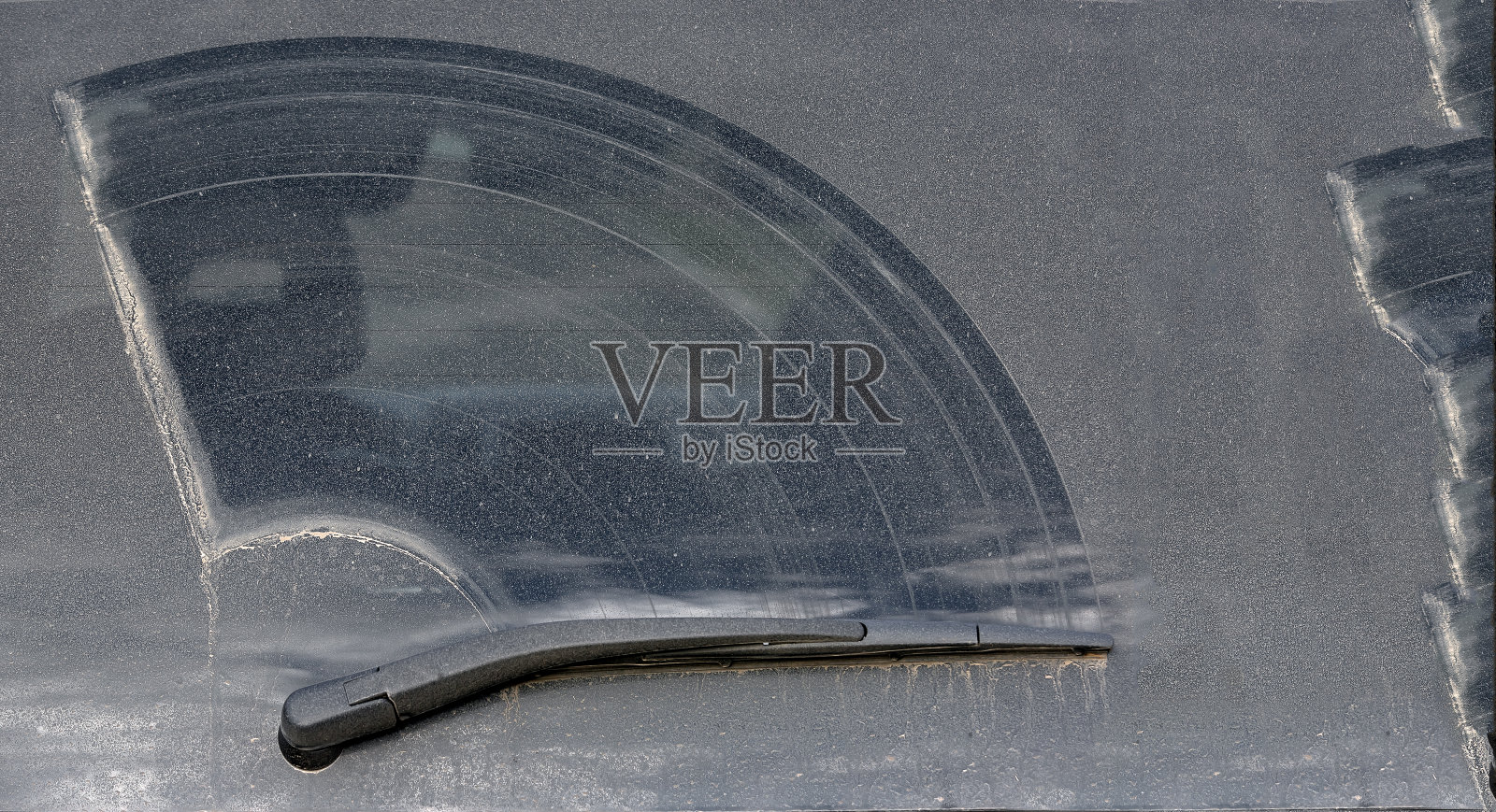 一辆脏车的后窗上覆盖着一层干污物，道路车辆的刮水器有缺陷。照片摄影图片