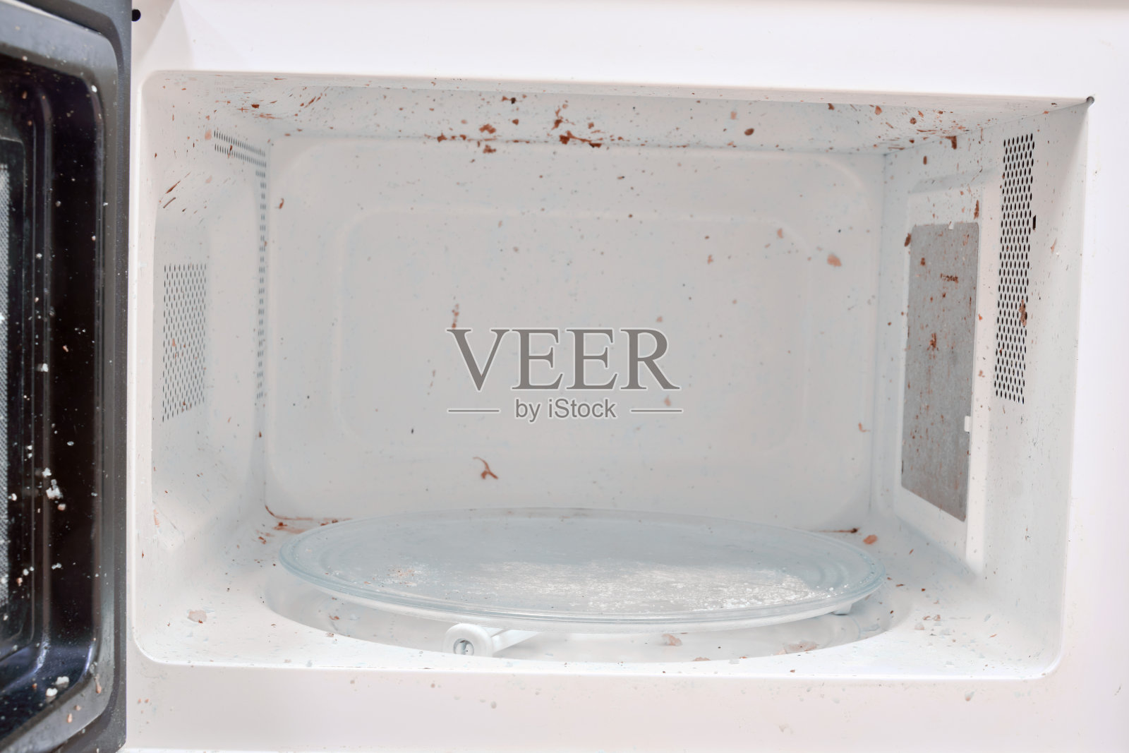 脏微波炉里的剩菜，关起来。卫生问题和厨房用具的清洁照片摄影图片