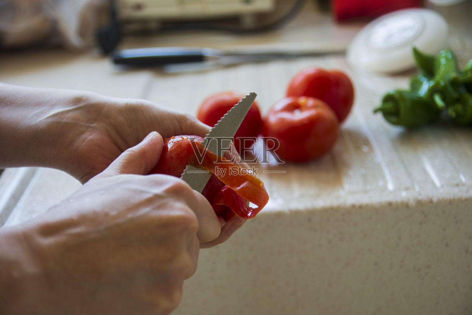 女人正在用刀削西红柿皮照片摄影图片