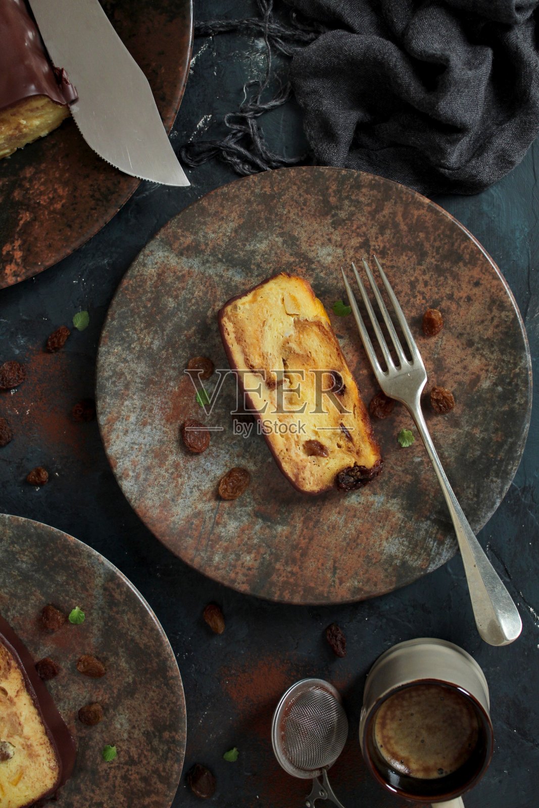 面包布丁蛋糕与葡萄干和巧克力在黑暗的背景。照片摄影图片