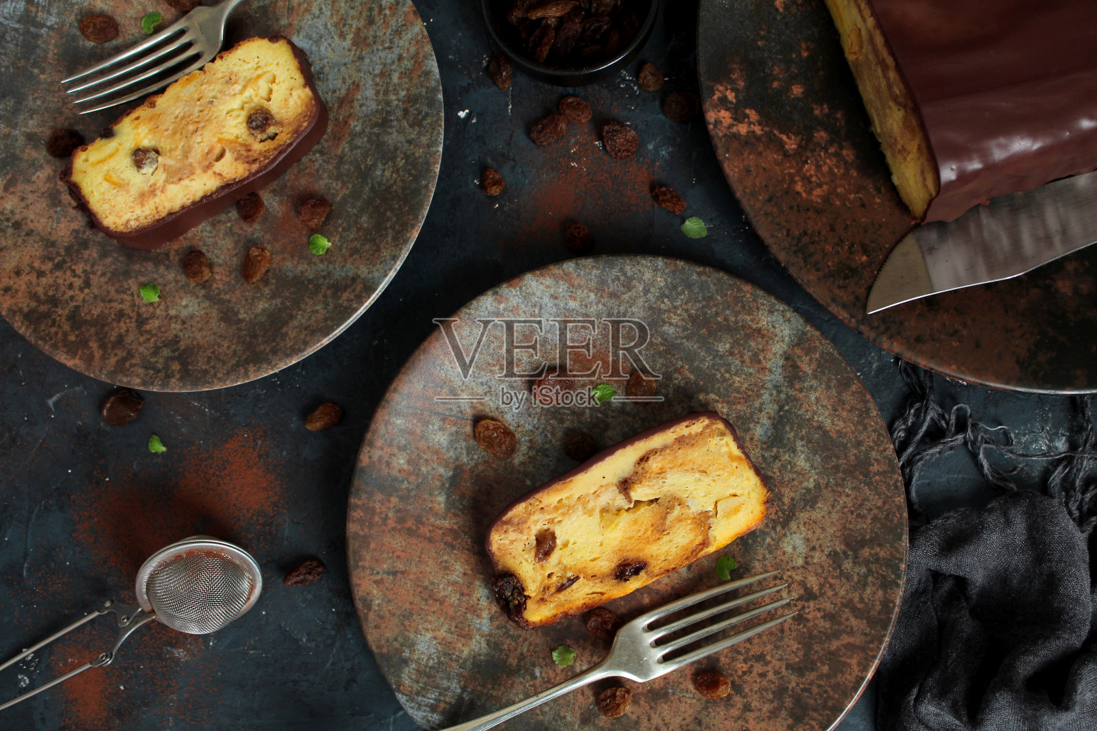 面包布丁蛋糕与葡萄干和巧克力在黑暗的背景。照片摄影图片