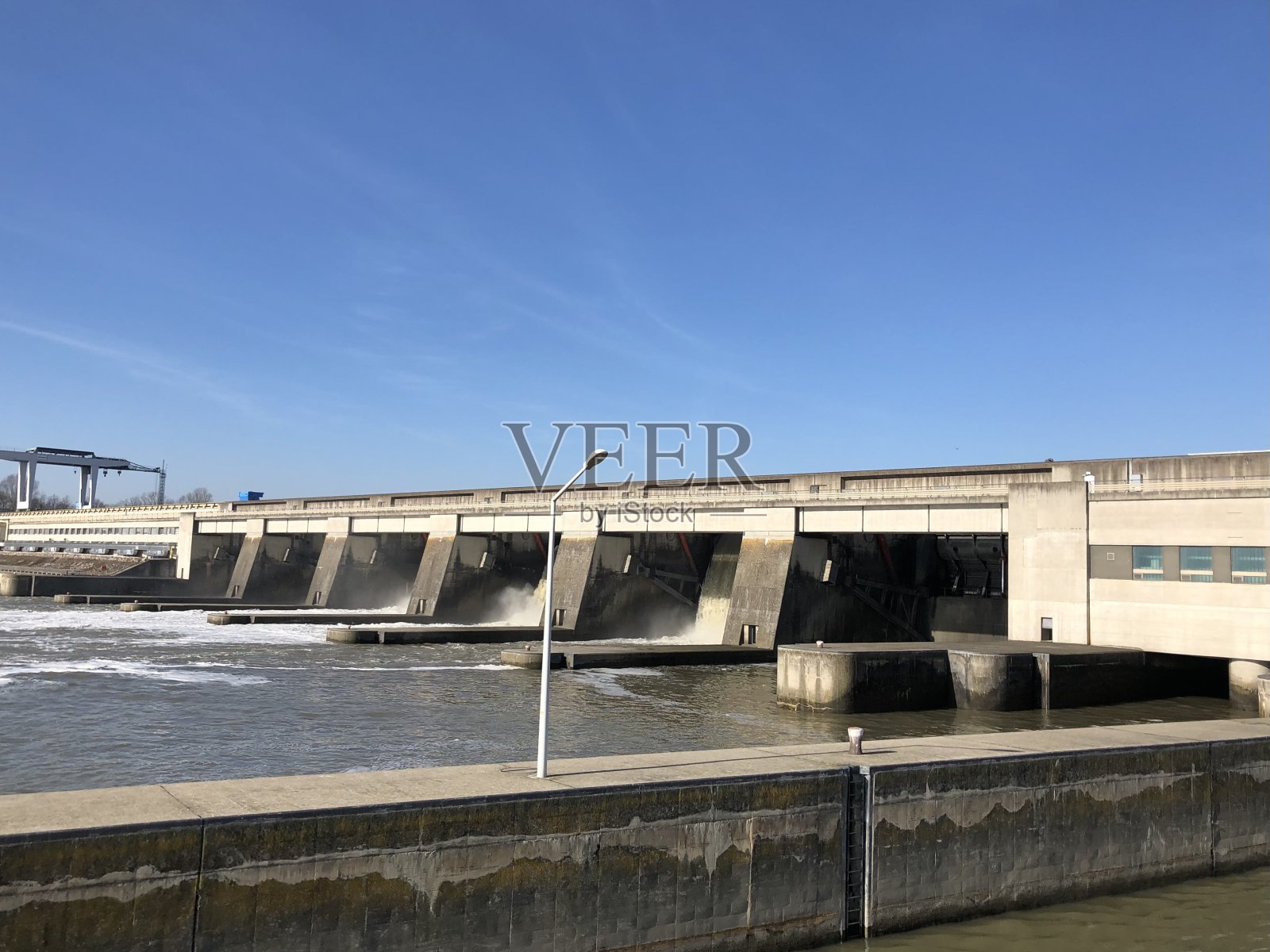 河上游船船尾的多瑙河和入口处的闸坝在早晨日出照片摄影图片