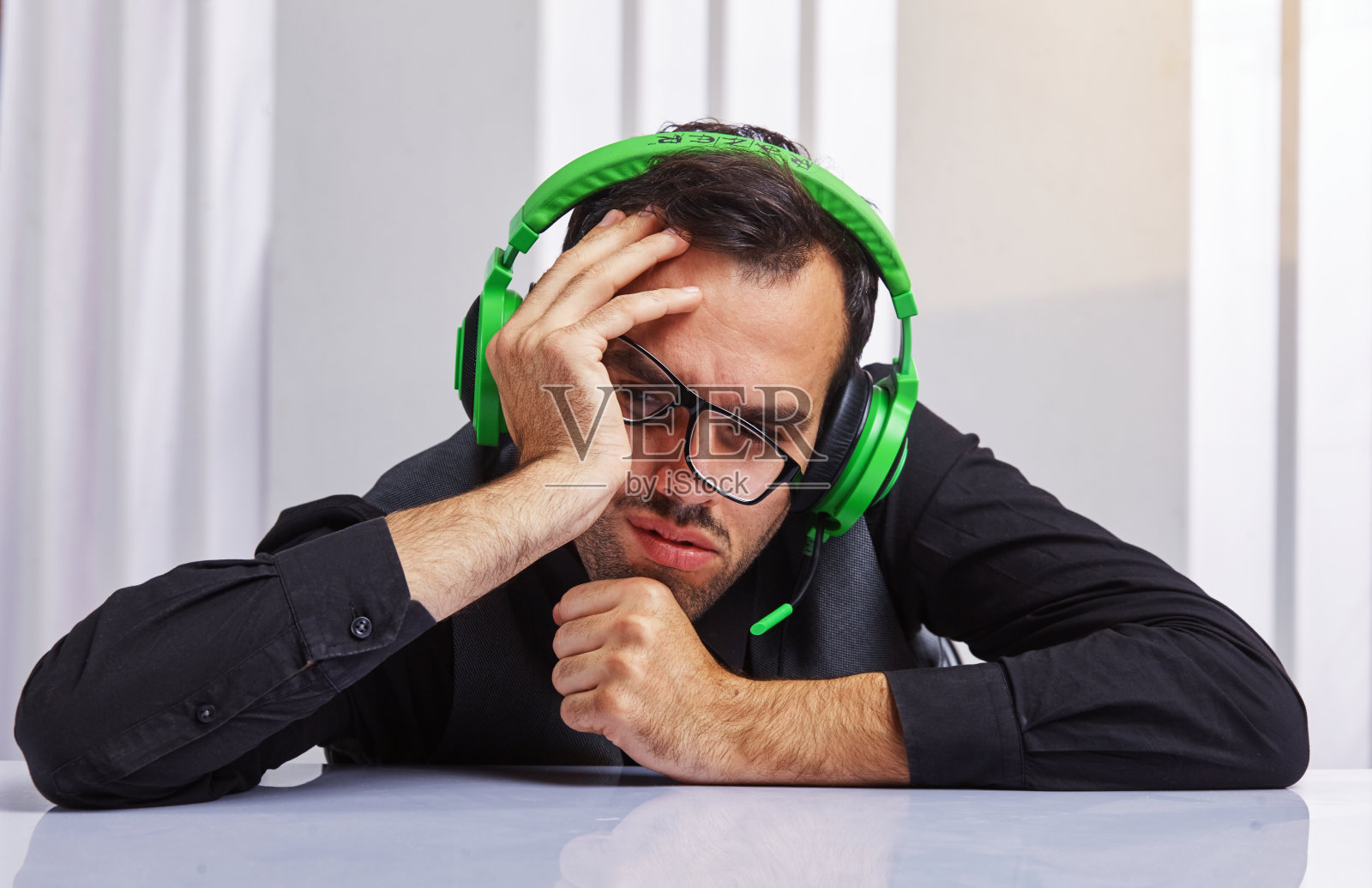 戴着耳机的呼叫中心接线员劳累了一天照片摄影图片