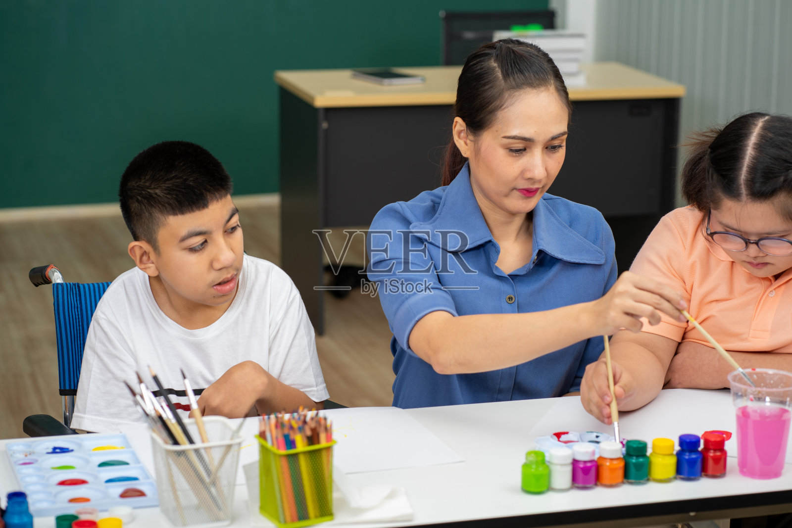 患有自闭症的亚洲残疾儿童在教室里学习彩色绘画照片摄影图片