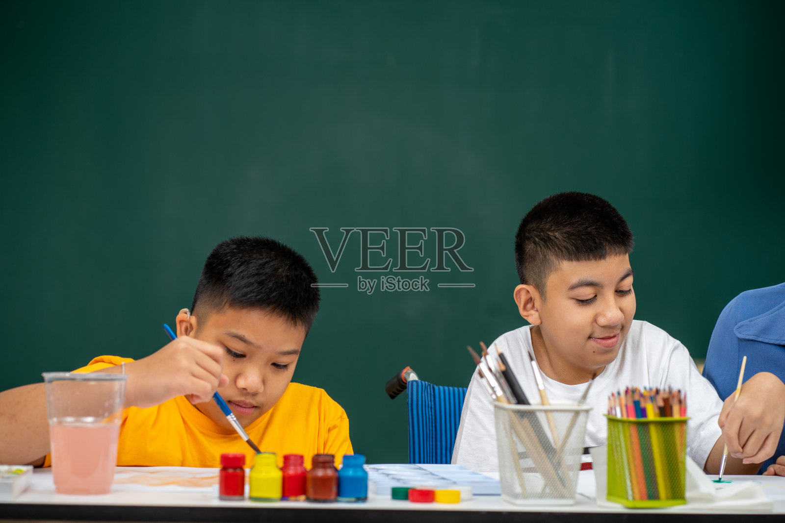 患有自闭症的亚洲残疾儿童在教室里学习彩色绘画照片摄影图片