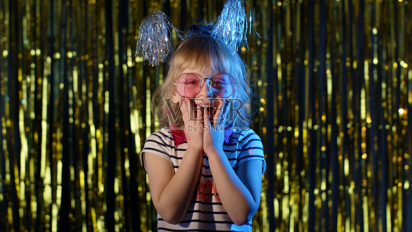 时髦的女孩用大大的眼睛惊讶地看着镜头举起手来，被胜利惊呆了，说哇照片摄影图片