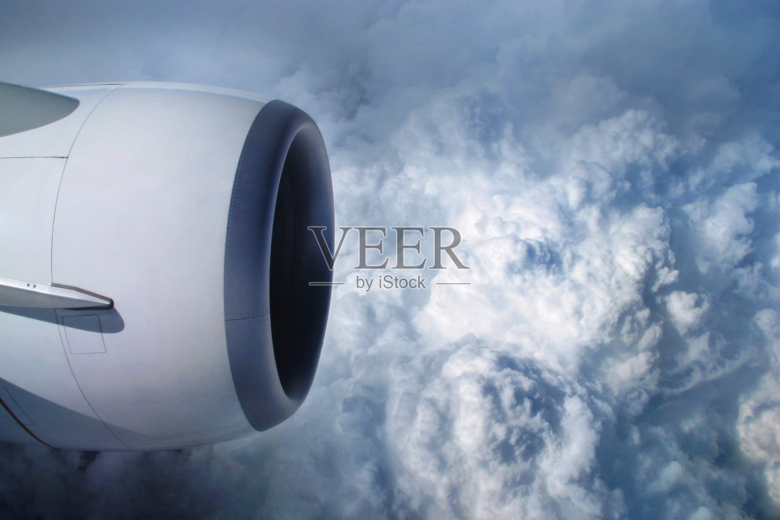 从飞机舷窗看天空和云。喷气发动机涡轮透过飞机窗户看照片摄影图片