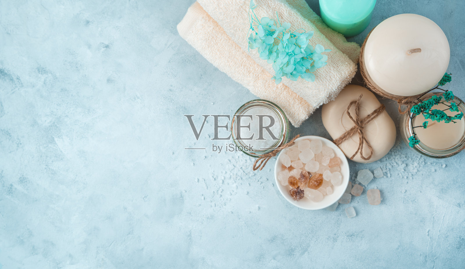 水疗设置与护理产品在一个柔和的蓝色背景。侧视图,全景照片摄影图片