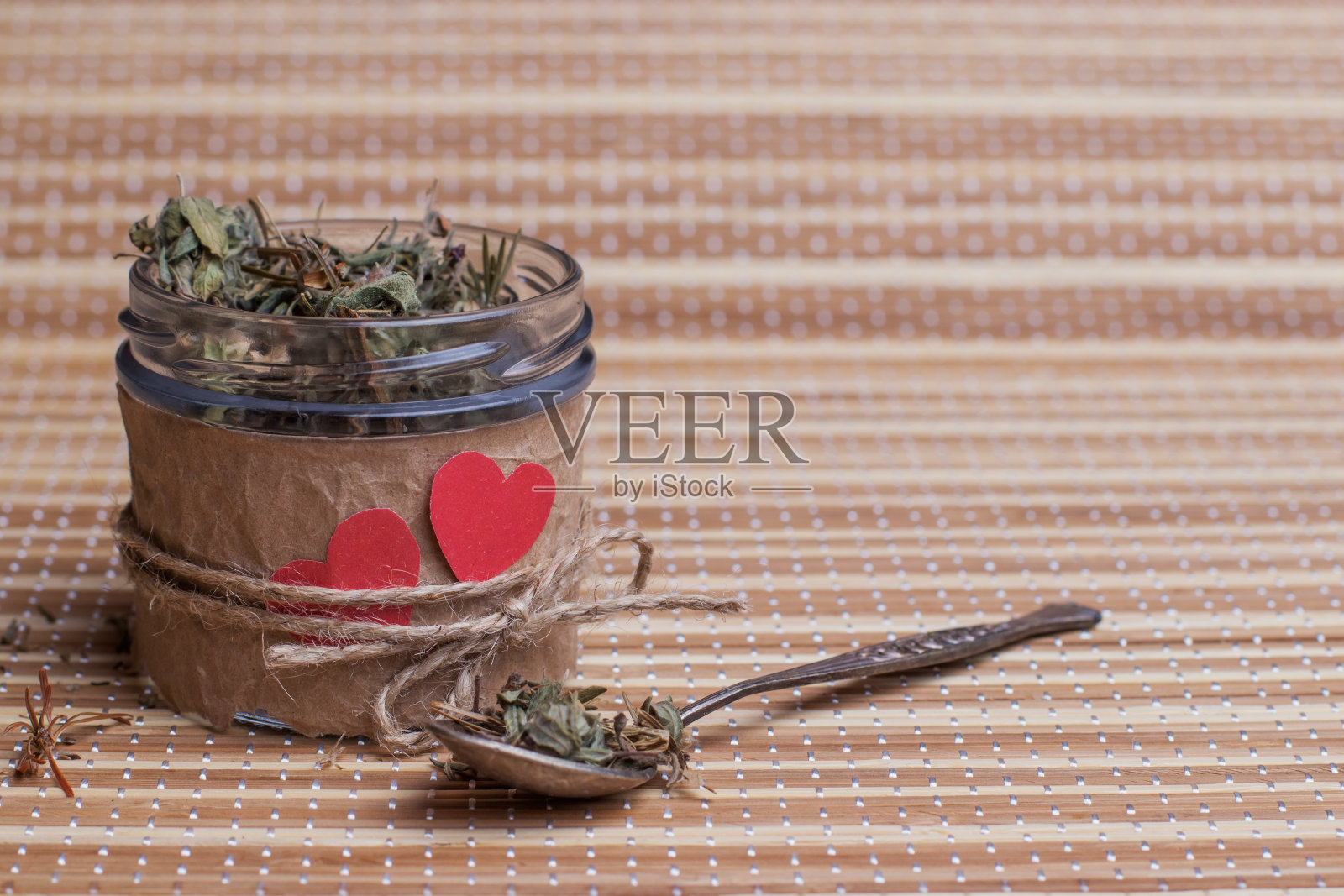 装有凉茶和心形假日装饰的玻璃罐。照片摄影图片