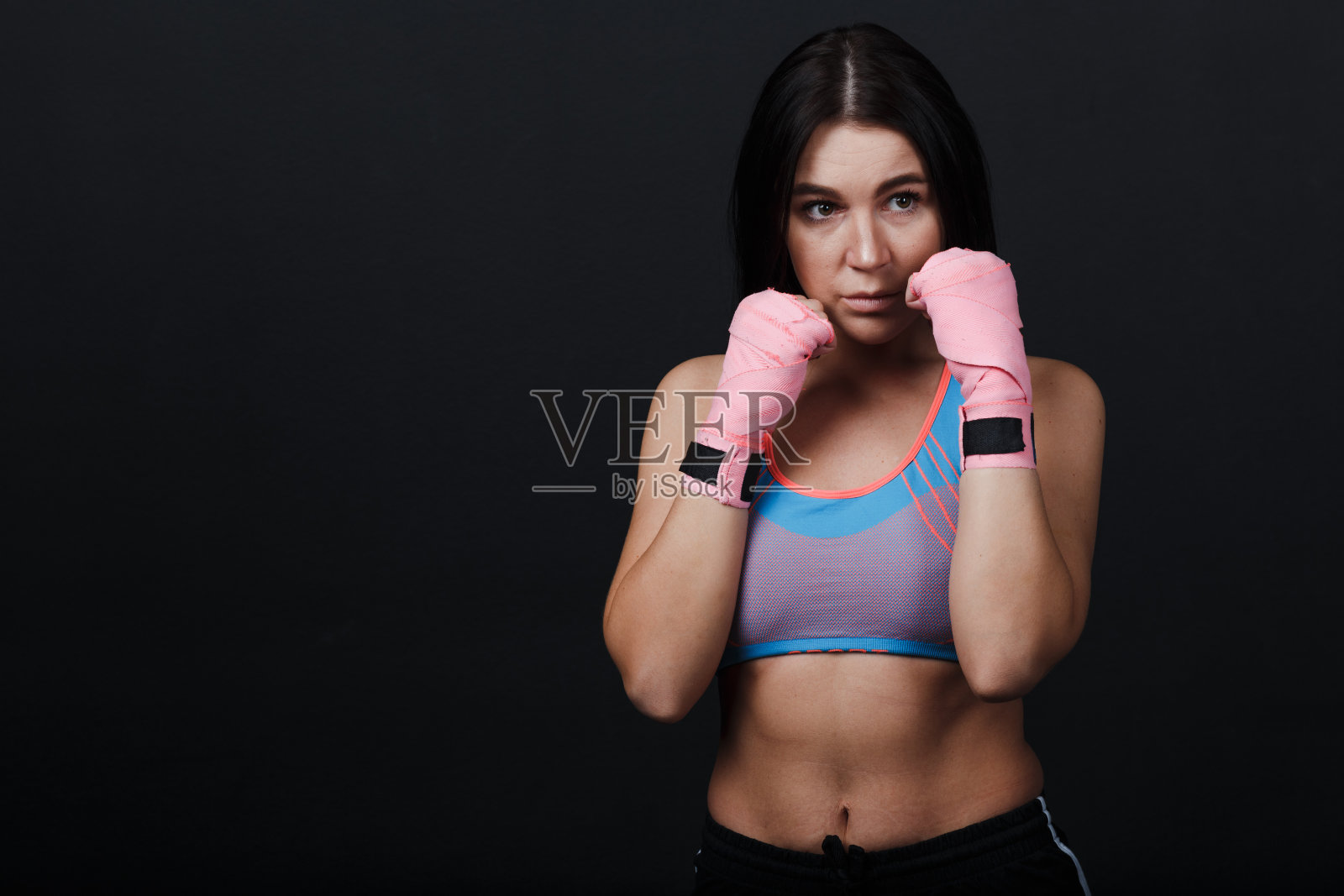 运动员泰拳女子肖像在训练工作室在黑色的背景。照片摄影图片