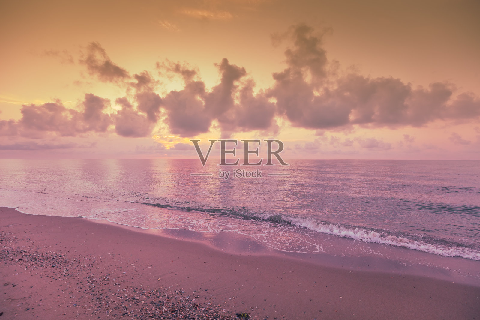 清晨在海滩上。粉红色紫色的日出在海上。柔和的颜色照片摄影图片