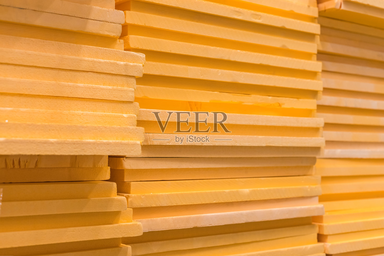 一小片橙色的聚苯乙烯泡沫挤成一堆。地基保温。照片摄影图片