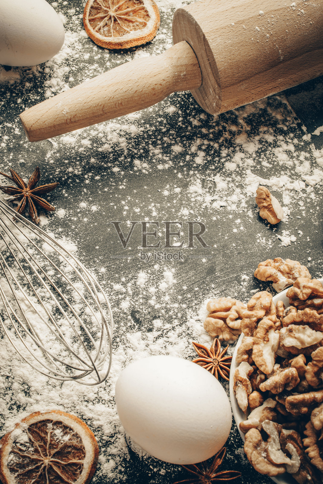 面包店的平面设计。烹饪食物配料:面粉，鸡蛋，坚果和八角，橙色在黑暗的餐桌厨房背景蛋糕。顶部视图与复制空间的文本，食谱，菜单。照片摄影图片