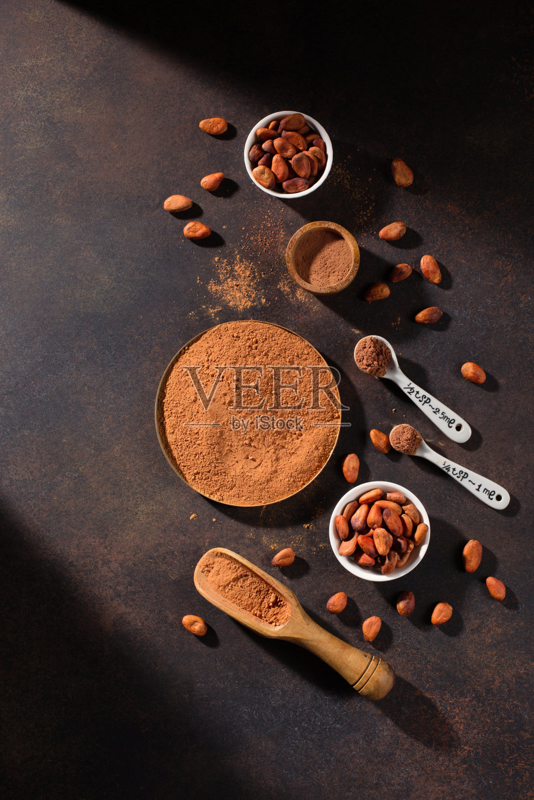 碗与有机可可粉和芳香的生可可豆在黑暗的乡村木质背景。照片摄影图片