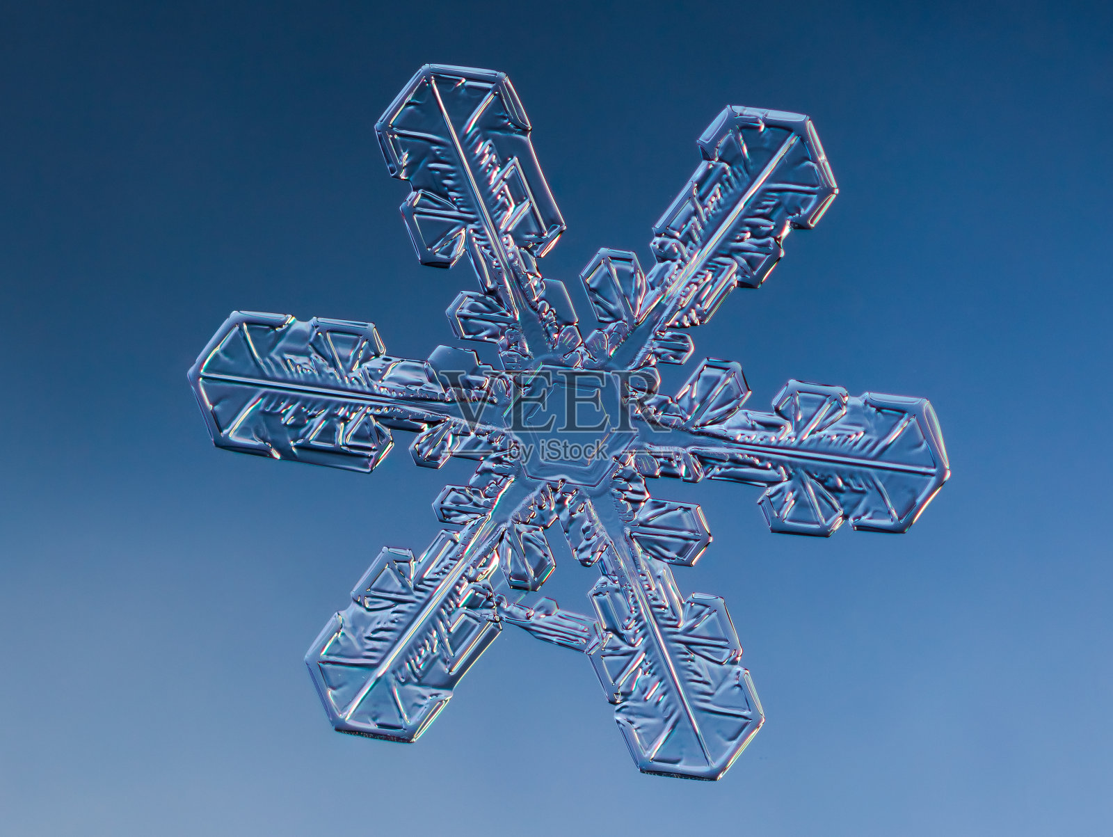 雪花在平滑的梯度背景。微距照片真实的雪晶玻璃表面。这是一小片有着不寻常图案的雪花。照片摄影图片