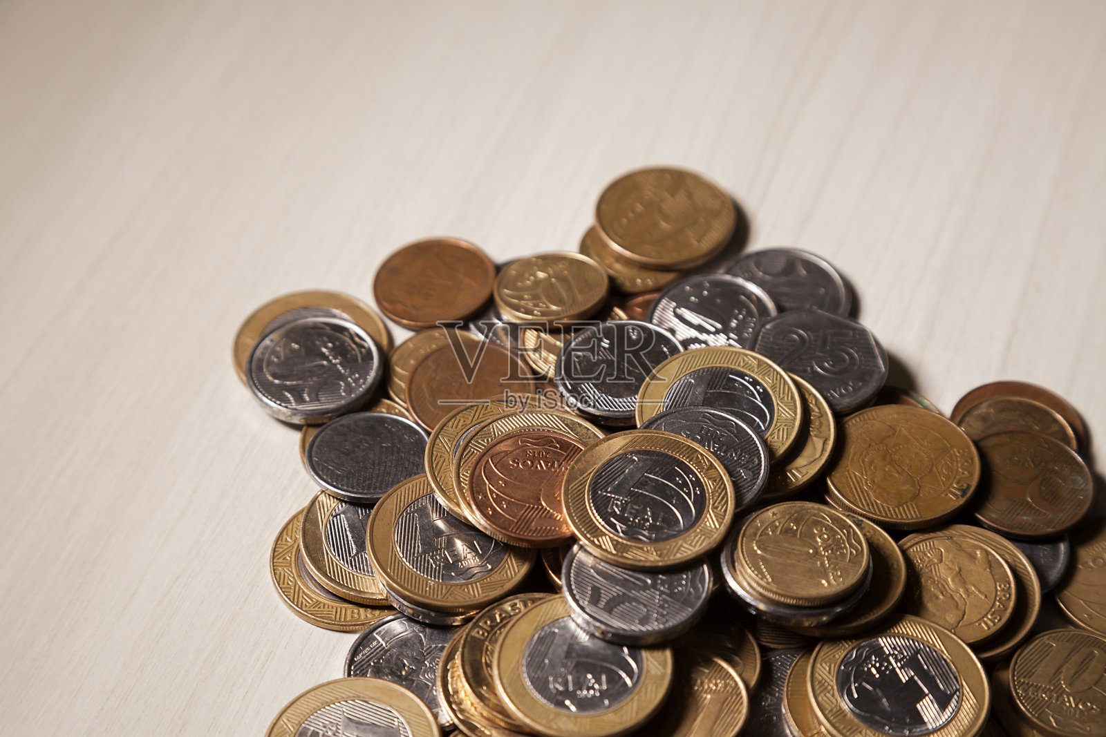 桌上放着从储蓄罐里取出的巴西(真)硬币。照片摄影图片