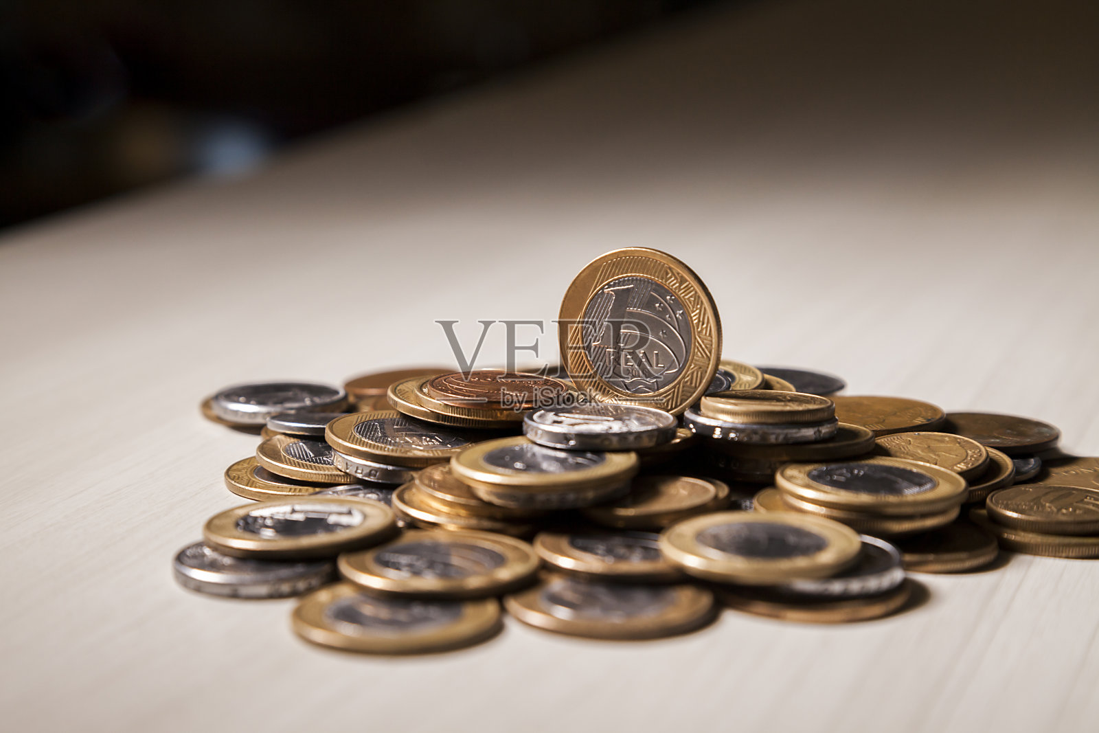 桌上有巴西硬币，上面有一枚真硬币。照片摄影图片