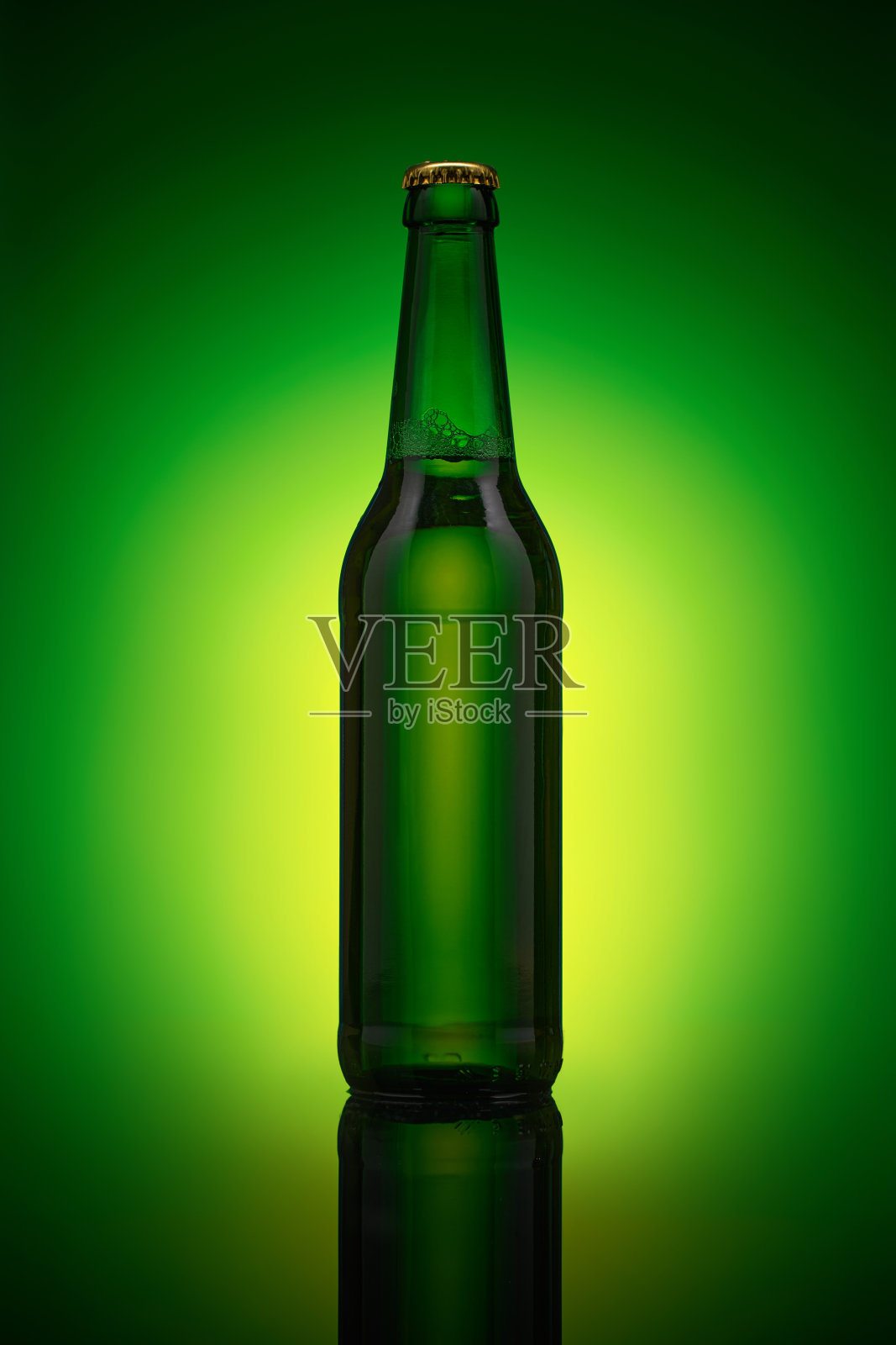 绿色啤酒瓶立在镜面上。照片摄影图片