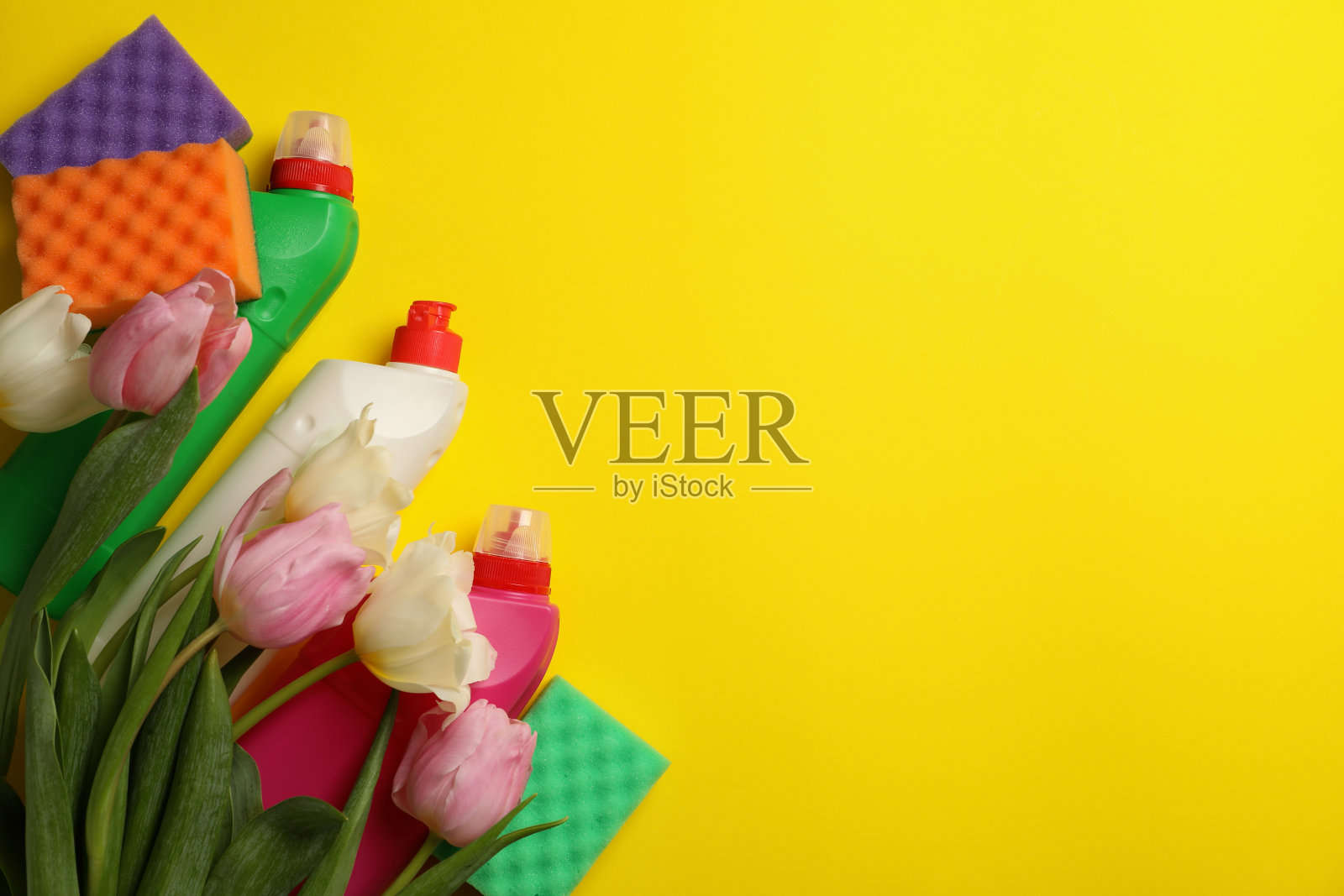 洗涤剂，海绵和郁金香在黄色的背景照片摄影图片