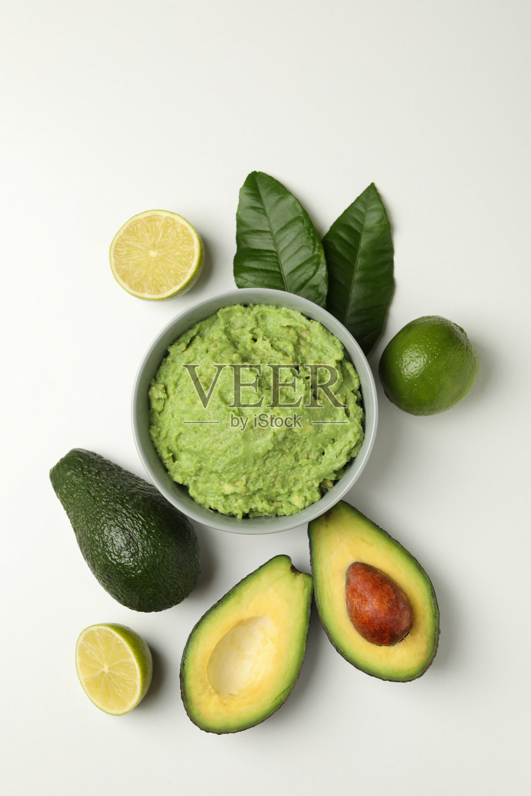 一碗鳄梨色拉酱，鳄梨和酸橙，白色背景，俯视图照片摄影图片