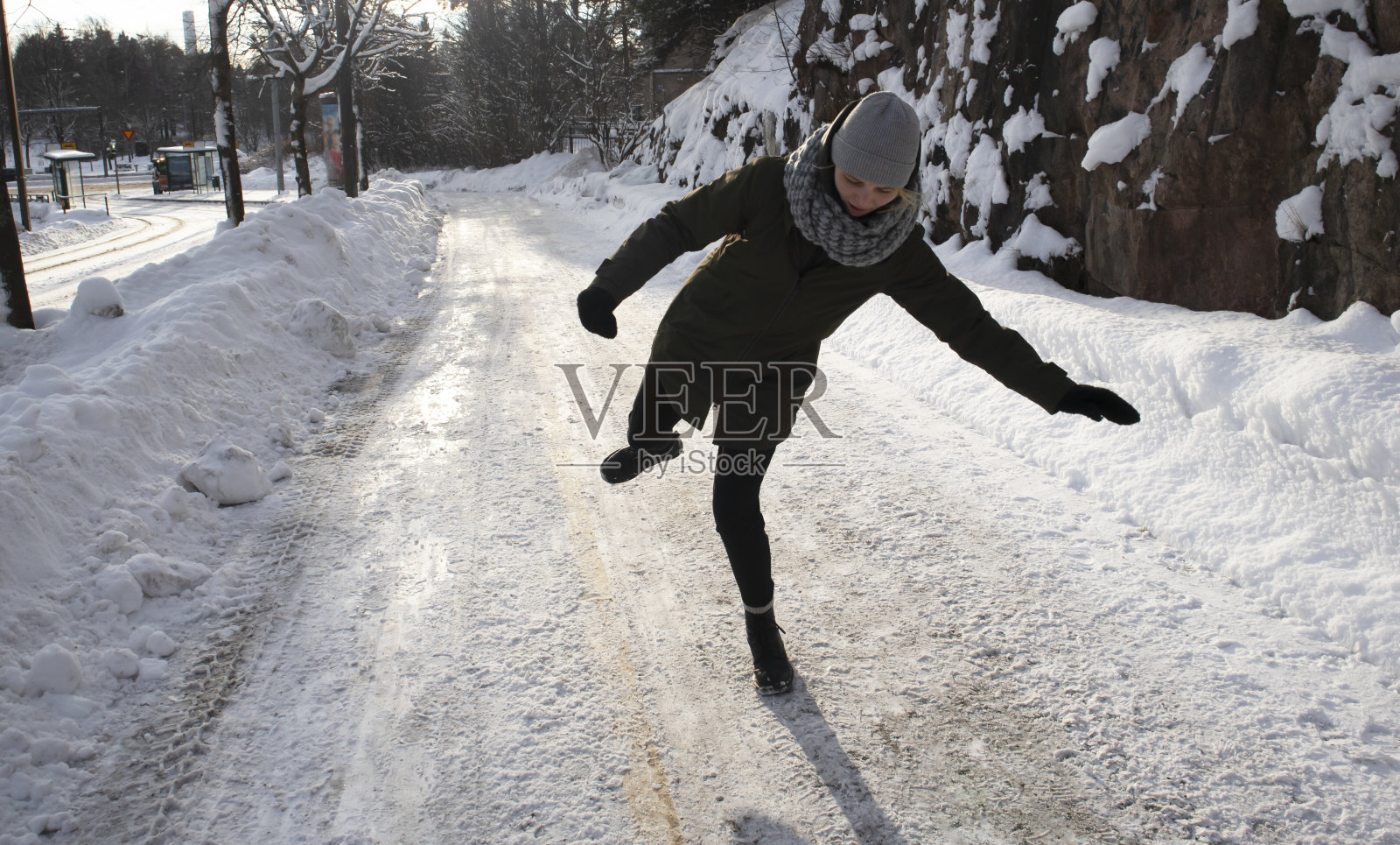 冬天，一个女人倒在结冰的街道上照片摄影图片