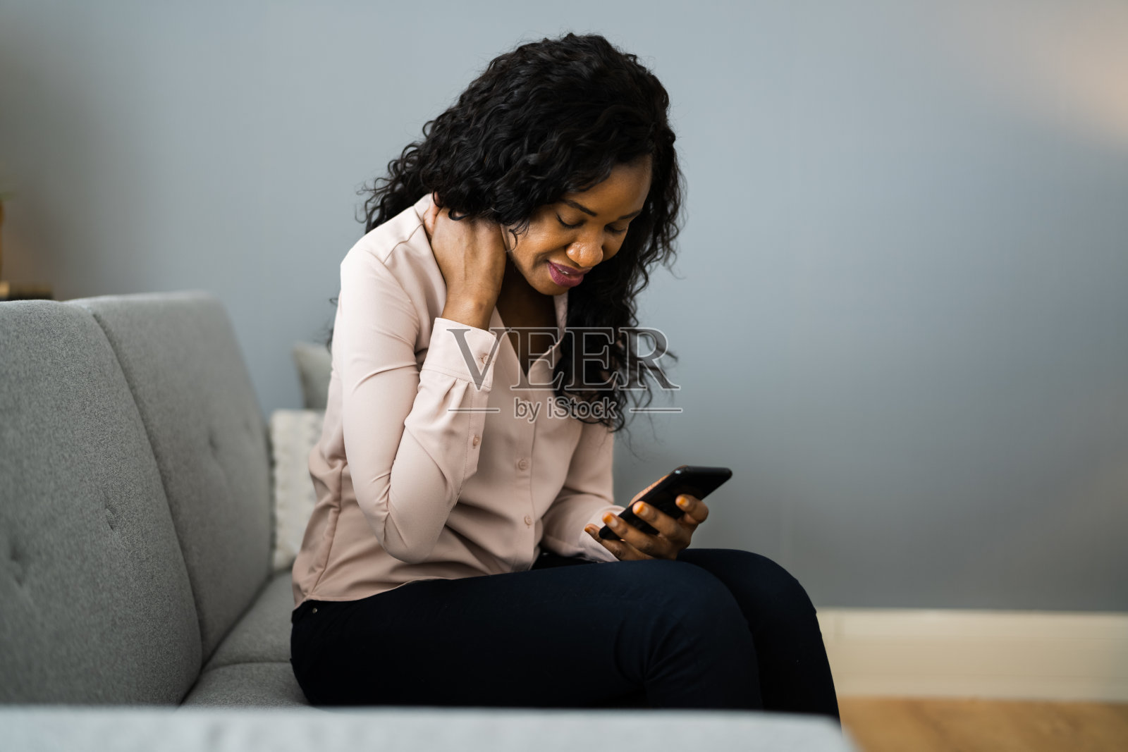 拿着手机坐着的女人后背疼照片摄影图片