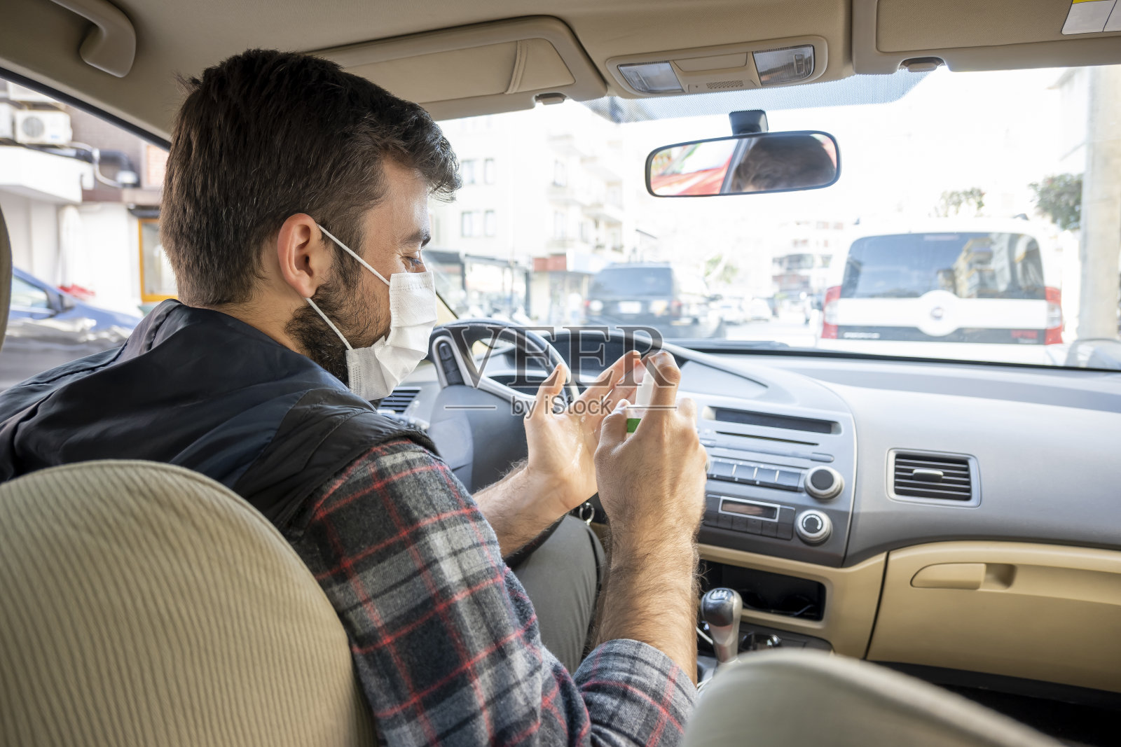 帅气的在车里为冠状病毒喷洒消毒剂照片摄影图片