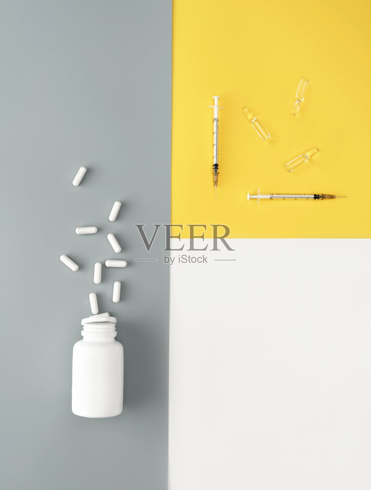 模型瓶与溢出的药丸，注射器和安瓿孤立的白色，时髦的黄色和灰色背景。美容医学概念。照片摄影图片