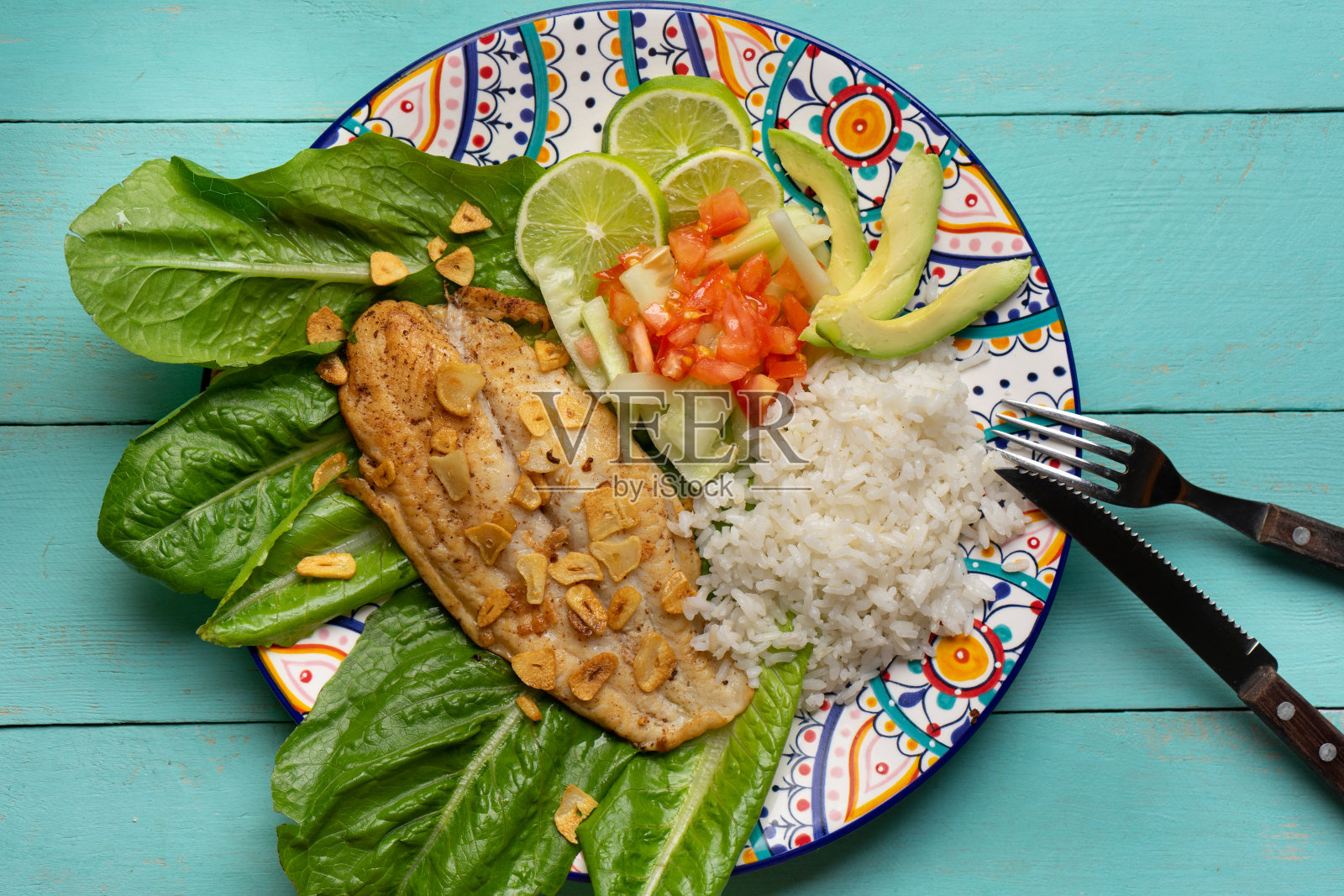 鱼排配大蒜，沙拉和米饭，绿松石背景照片摄影图片
