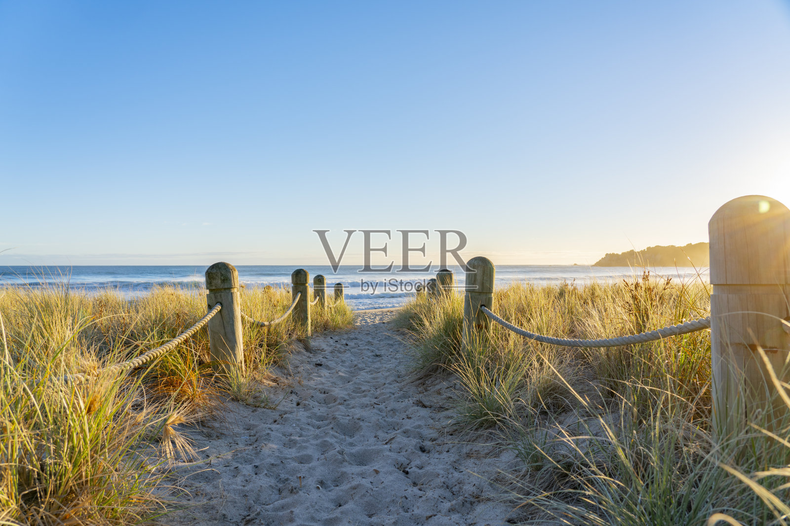 在护柱和沙丘之间通往海滩的路径照片摄影图片