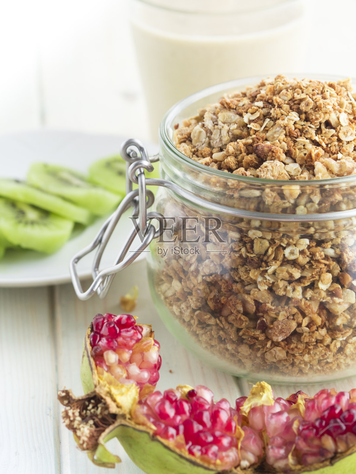 自制的燕麦和坚果，新鲜水果(猕猴桃和石榴)和蔬菜牛奶照片摄影图片