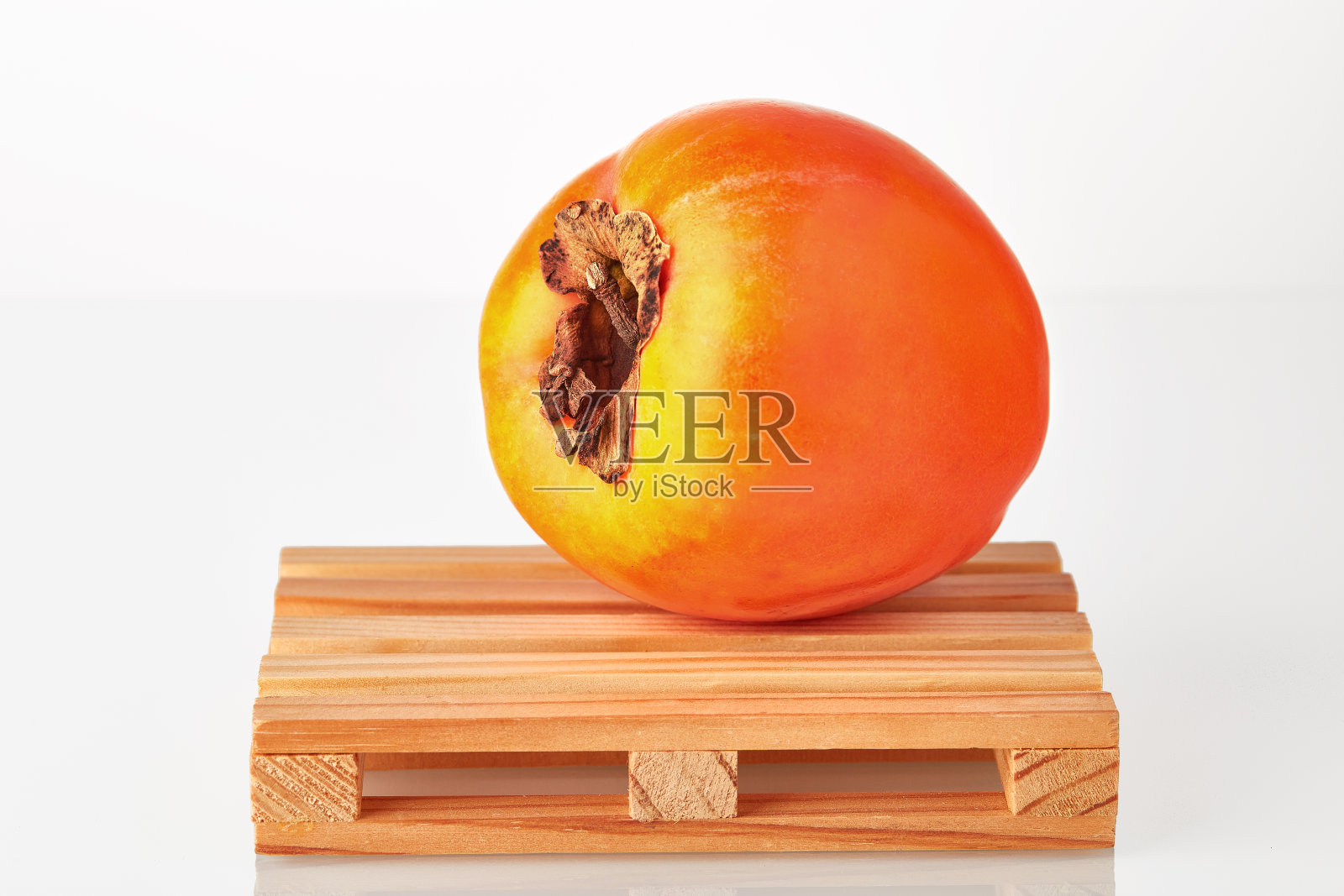 新鲜的柿子在物流托盘上等待运输到目的地，隔离在白色的背景。水果出口或进口。照片摄影图片