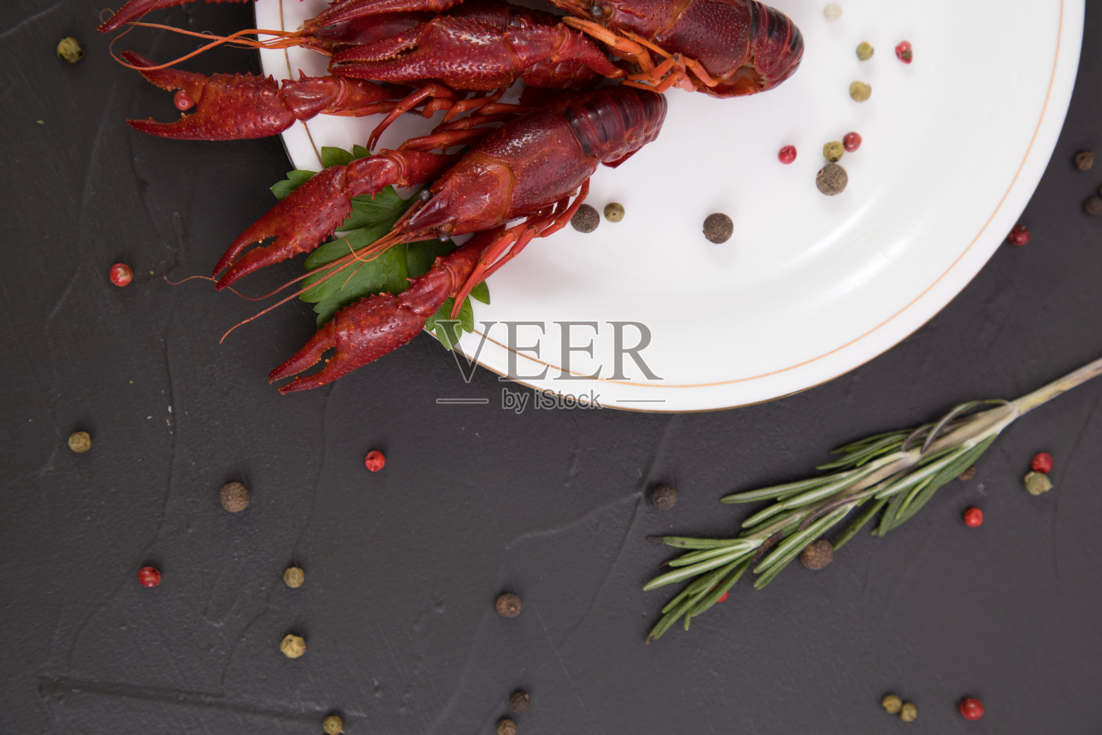 美味的水煮小龙虾放在一个白色盘子里，配上胡椒，柠檬和欧芹。为你的文本留出空间。照片摄影图片